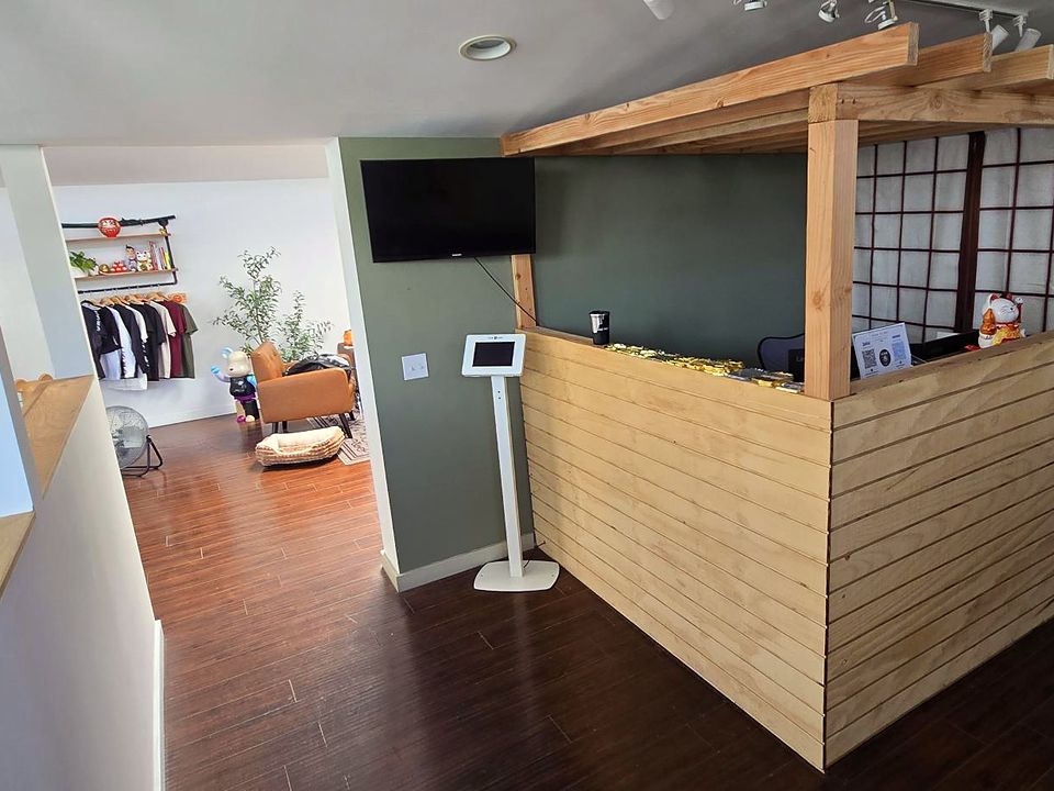 The wood-slat front desk with shoji screens and a check-in kiosk