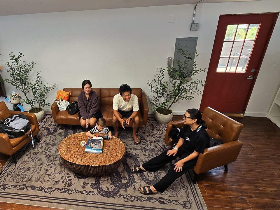 Members relaxing and laughing on the leather couches in the KŌBŌ lounge