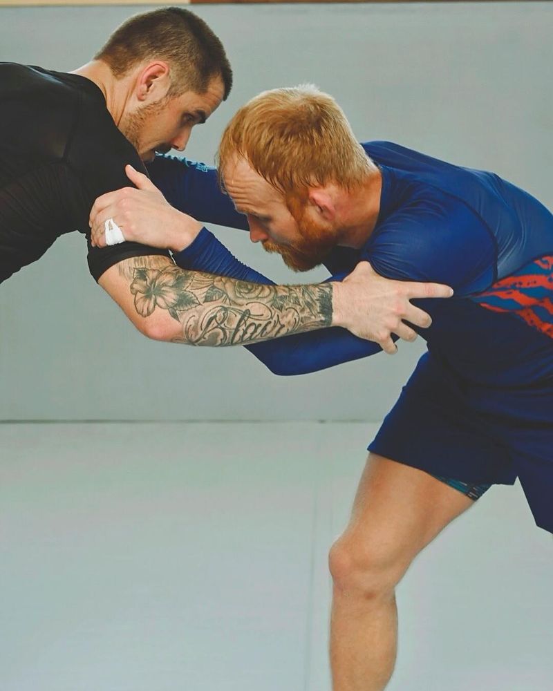 Two grapplers in rashguards fighting for a tie-up